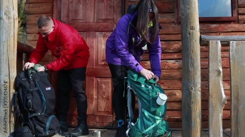Packing a tourist backpack. Wooden house in the mountains. Tourist clothes. Ukrainian Carpathian Mountains.