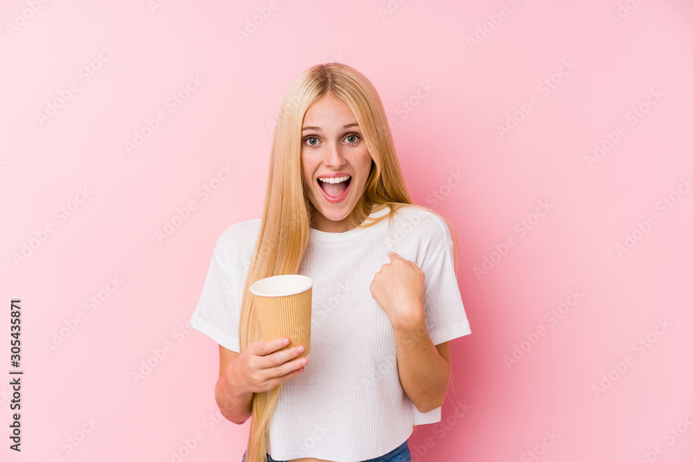 Young blonde girl holding a takeaway coffee surprised pointing at himself, smiling broadly. Young blonde girl holding a takeaway coffee surprised pointing at himself, smiling broadly.