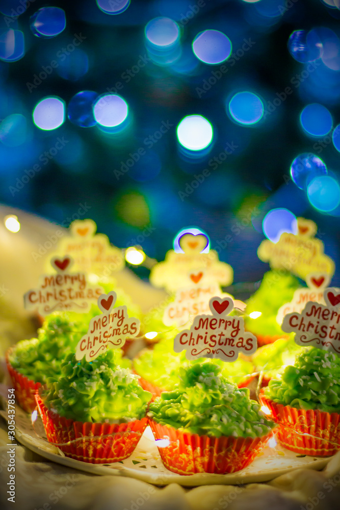 Christmas baking. Green Christmas cupcakes with the inscription Merry Christmas. Sweets for the Christmas table. Christmas sweets close-up.