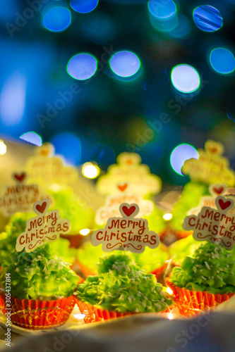 Christmas baking. Green Christmas cupcakes with the inscription Merry Christmas. Sweets for the Christmas table. Christmas sweets close-up.