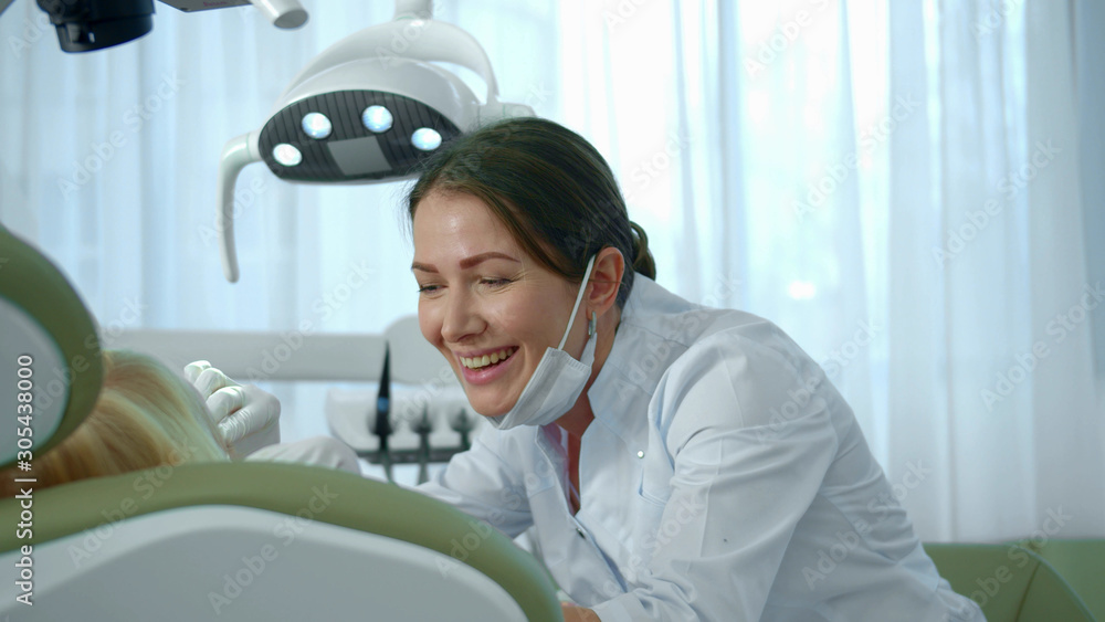 Naklejka premium Doctor looked at the girls teeth and continued to speak with her.