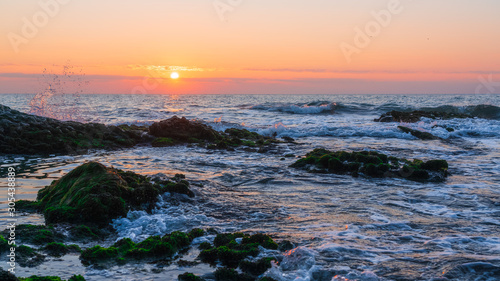 Colorful sunrise on a rocky seashore