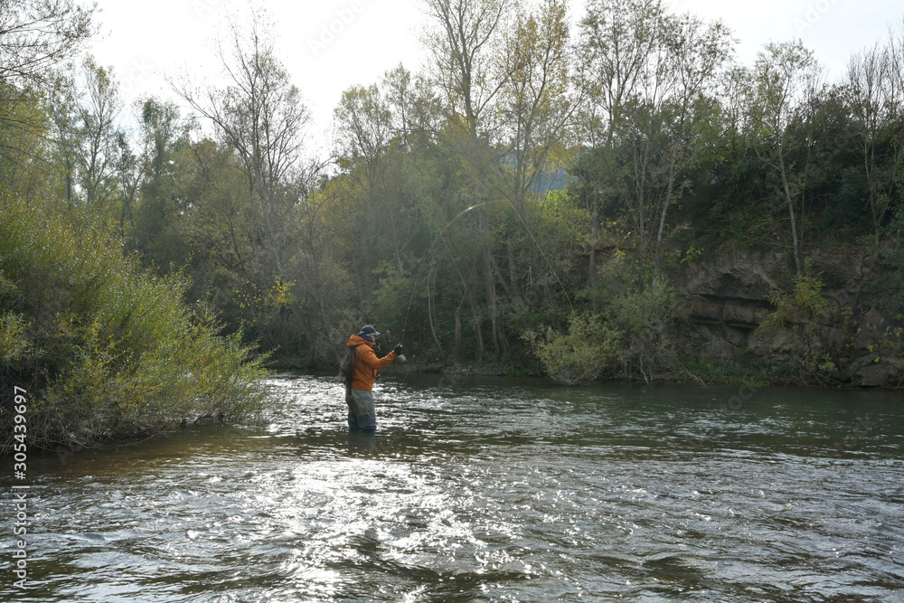 fly fisherman in river in autumn fly fisherman in river in autumn