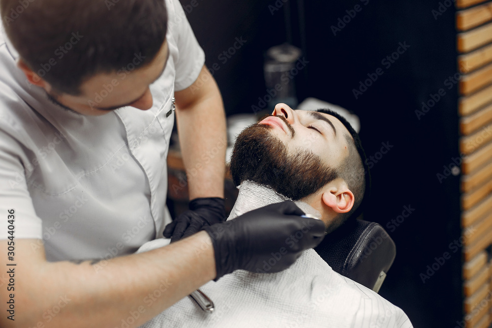 Fototapeta premium Man with a beard. Hairdresser with a client.