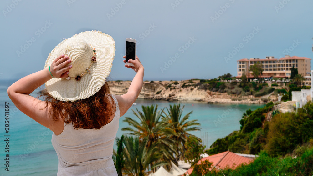 Fototapeta premium attractive woman photographs herself at sea, sea trip on vacation selfie
