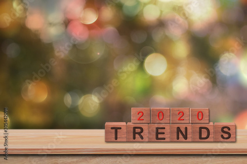 Wooden blocks with the word Trends 2020 on wood table with bokeh background. Idea of happy new year 2020 holiday