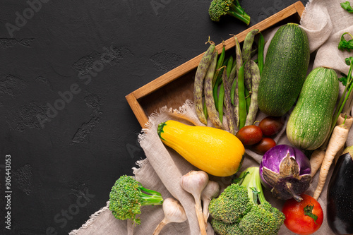 фотографія Organic and fresh vegetables inside wooden box on fief canvas