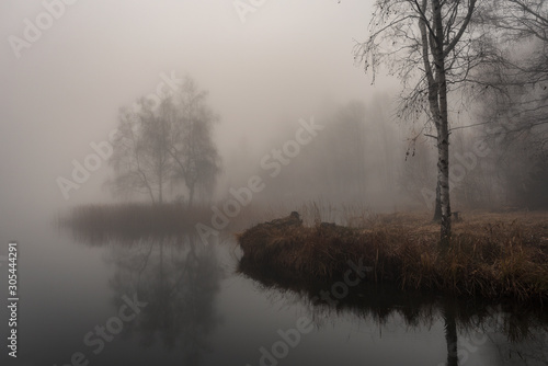 Autumn landscape with deep mist on the lake 