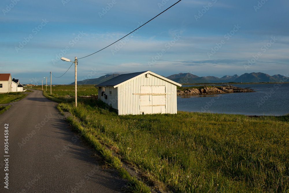 Rorbu house. Fishing hut in beautiful nature landscape. Amazing scenic outdoors view. Ocean and mountains. Dramatic clouds. Tourist landmark. Travel and adventure lifestyle. Explore North Norway