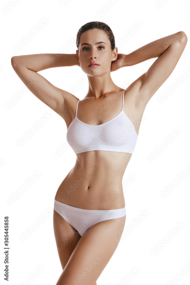 Young woman in white underwear, with bundled hair, put hands on head, posing isolated on white. Plastic surgery, aesthetic cosmetology. Close-up. Young woman in white underwear, with bundled hair, put hands on head, posing isolated on white. Plastic surgery, aesthetic cosmetology. Close-up.