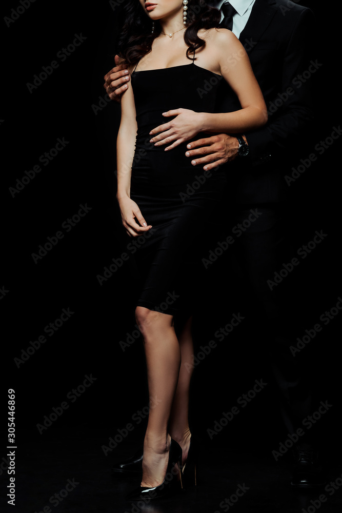 cropped view of man standing and hugging girl isolated on black
