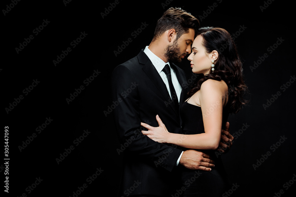 side view of handsome bearded man with closed eyes hugging attractive girl isolated on black side view of handsome bearded man with closed eyes hugging attractive girl isolated on black