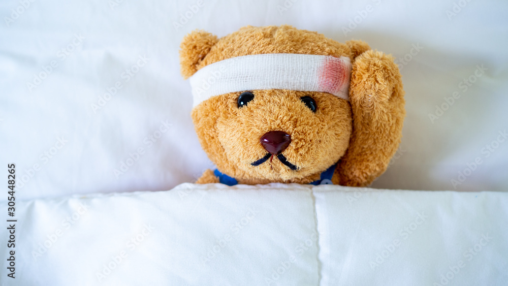 The teddy bear was sick in bed after being injured in an accident. Getting life insurance and accident insurance concept