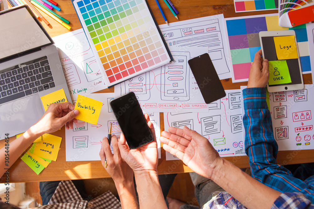 Obraz premium The web designer team is helping to design applications for mobile phones. UX UI designer concept