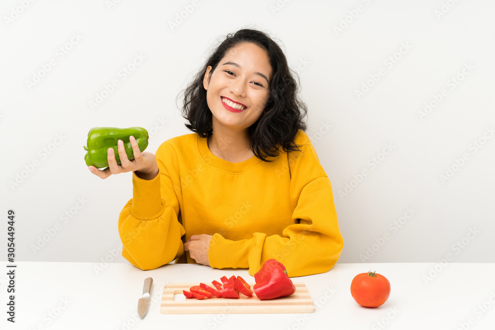 Young asian girl with vegetables in a table Young asian girl with vegetables in a table