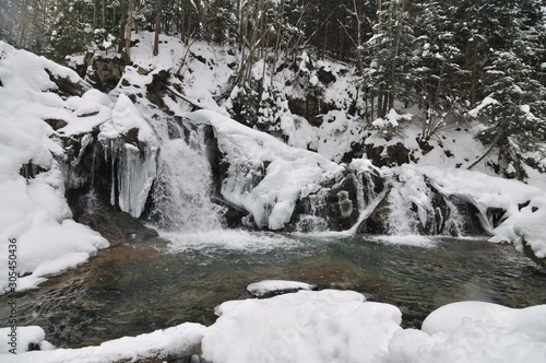 Beautiful snowy waterfall flowing in the mountains