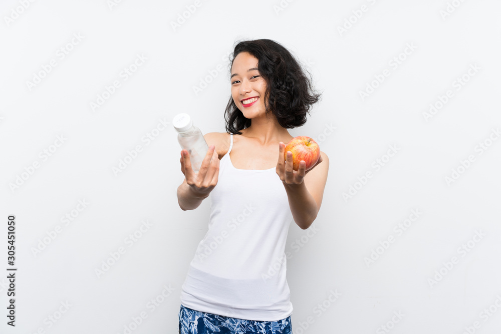 Asian young woman with an apple over isolated white background Asian young woman with an apple over isolated white background