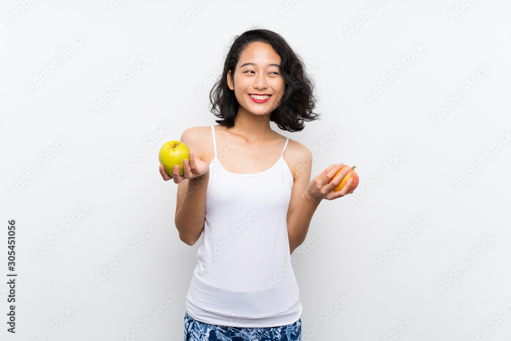 Asian young woman with an apple over isolated white background Asian young woman with an apple over isolated white background