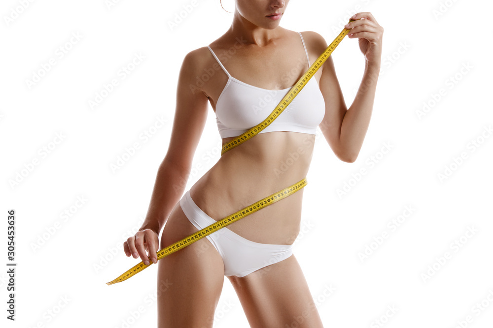 Perfect body of girl in white underwear measuring herself, posing isolated  on white. Plastic surgery and aesthetic cosmetology concept. Close-up.  Stock-Foto | Adobe Stock
