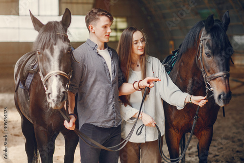 Couple on a ranch. Pair standing with a horse. Girl with her boyfriend