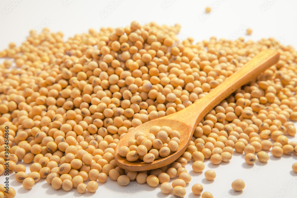 Soybeans background . Dry Soy bean or soya bean in a bowl with some soybeans in wooden spoon on white background Soybeans background . Dry Soy bean or soya bean in a bowl with some soybeans in wooden spoon on white background
