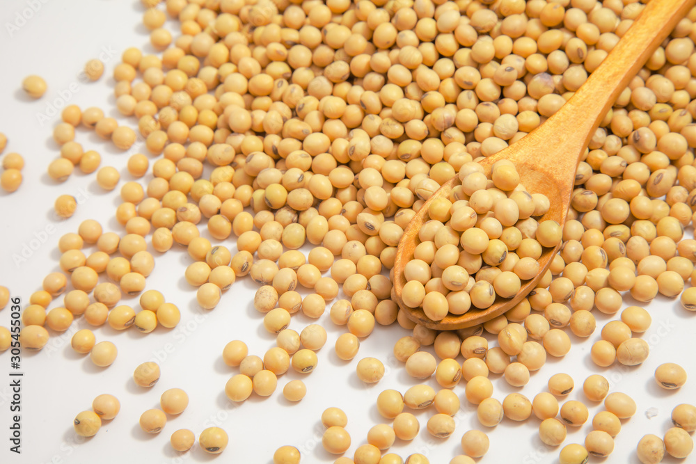 Soybeans background . Dry Soy bean or soya bean in a bowl with some soybeans in wooden spoon on white background Soybeans background . Dry Soy bean or soya bean in a bowl with some soybeans in wooden spoon on white background