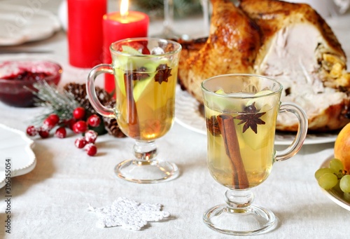 christmas hot cider. hot winter drink Cranberry Apple Cider Punch. Garnish with apples, oranges, and cranberries. hot apple cider with spices on a festive table on Christmas or New Year.