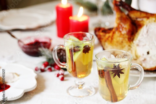 christmas hot cider. hot winter drink Cranberry Apple Cider Punch. Garnish with apples, oranges, and cranberries. hot apple cider with spices on a festive table on Christmas or New Year.