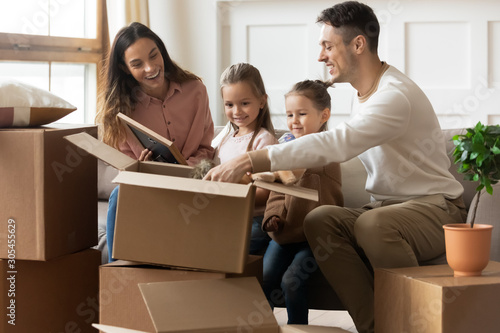 Happy family with children unpacking boxes on moving day