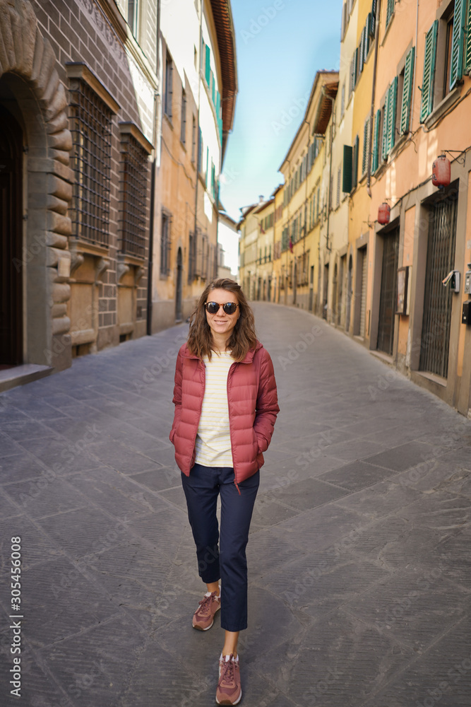 Happy young woman in typical Italian empty street.