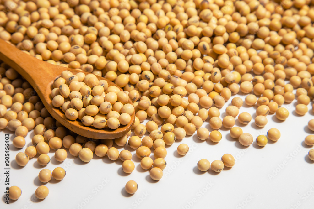 Soybeans background . Dry Soy bean or soya bean in a bowl with some soybeans in wooden spoon on white background Soybeans background . Dry Soy bean or soya bean in a bowl with some soybeans in wooden spoon on white background