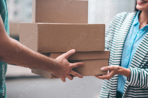 Close up of delivery man passing boxes with order to the customer © zinkevych