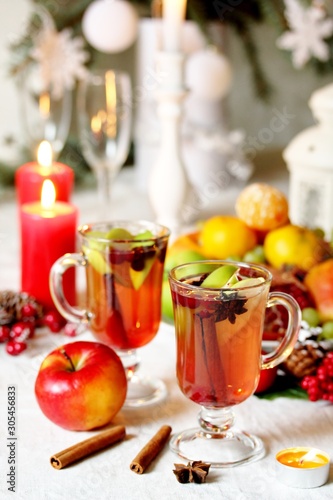 hot winter drink Cranberry Apple Cider Punch. Garnish with apples  oranges  and cranberries. hot apple cider with spices on a festive table on Christmas or New Year.