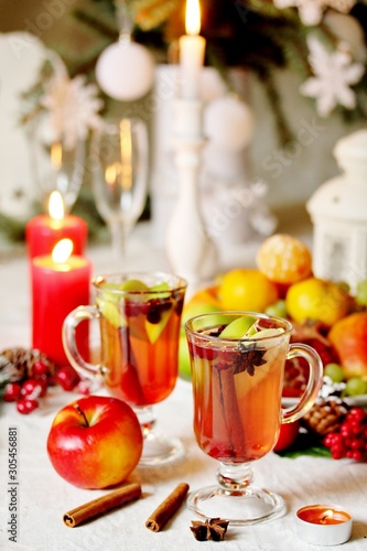 hot winter drink Cranberry Apple Cider Punch. Garnish with apples, oranges, and cranberries. hot apple cider with spices on a festive table on Christmas or New Year.