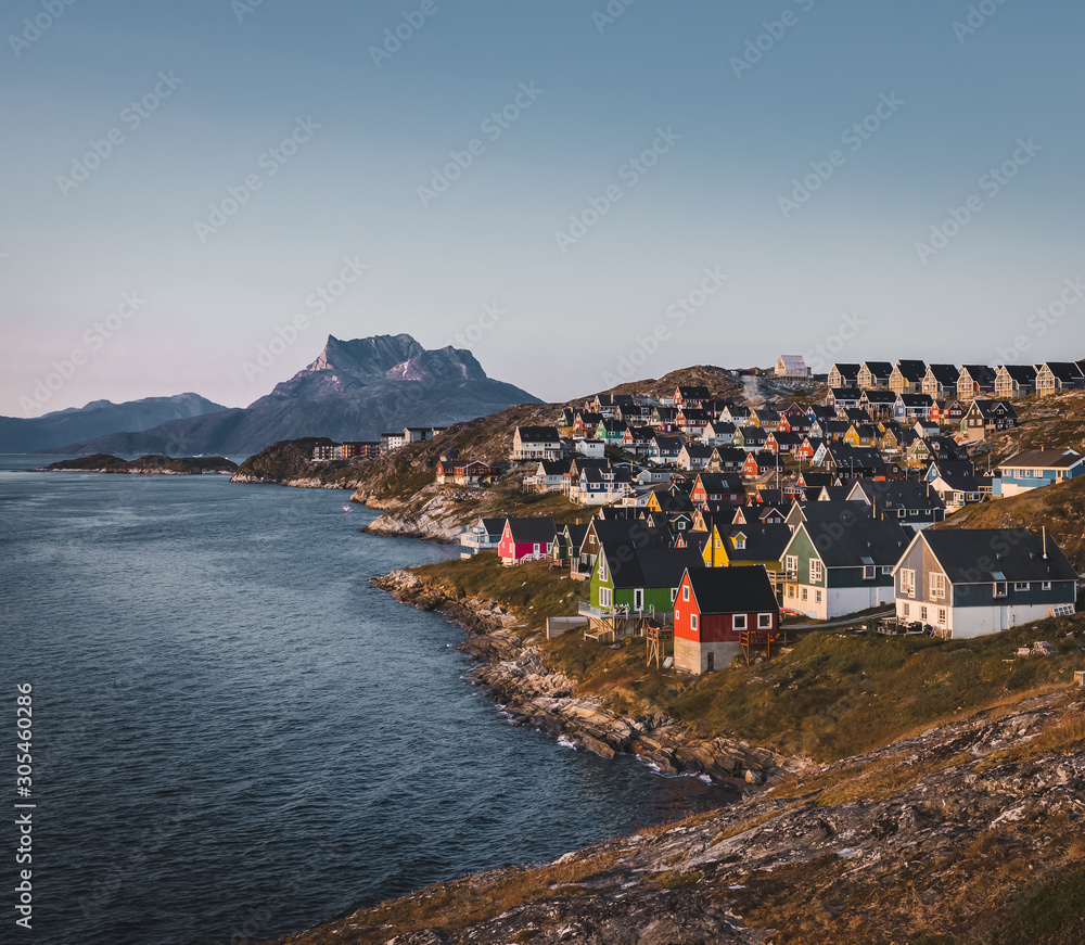 Nuuk capital of Greenland with Beautiful small colorful houses in myggedalen during Sunset Sunrise Midnight Sun. Sermitsiaq Mountain in Background. Blue and pink Sky.