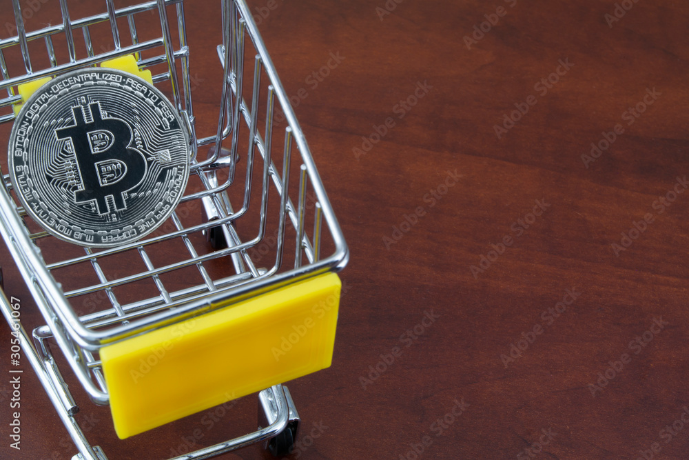 Shopping cart with bitcoin on wooden table with room for text Shopping cart with bitcoin on wooden table with room for text