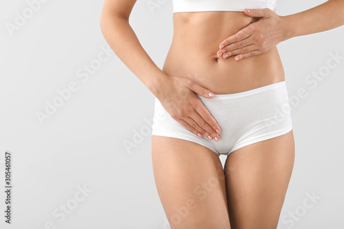 Young woman on grey background, closeup. Gynecology concept