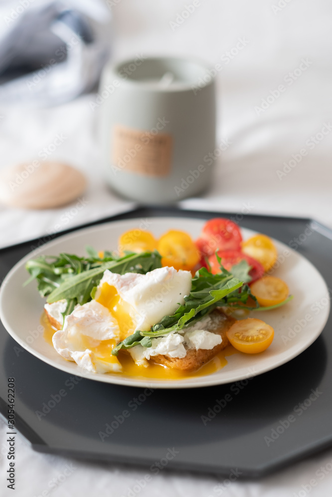 beautiful delicious breakfast, cherry tomatoes, greens and poached egg. beautiful delicious breakfast, cherry tomatoes, greens and poached egg.