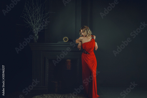 woman near the fireplace in a red dress