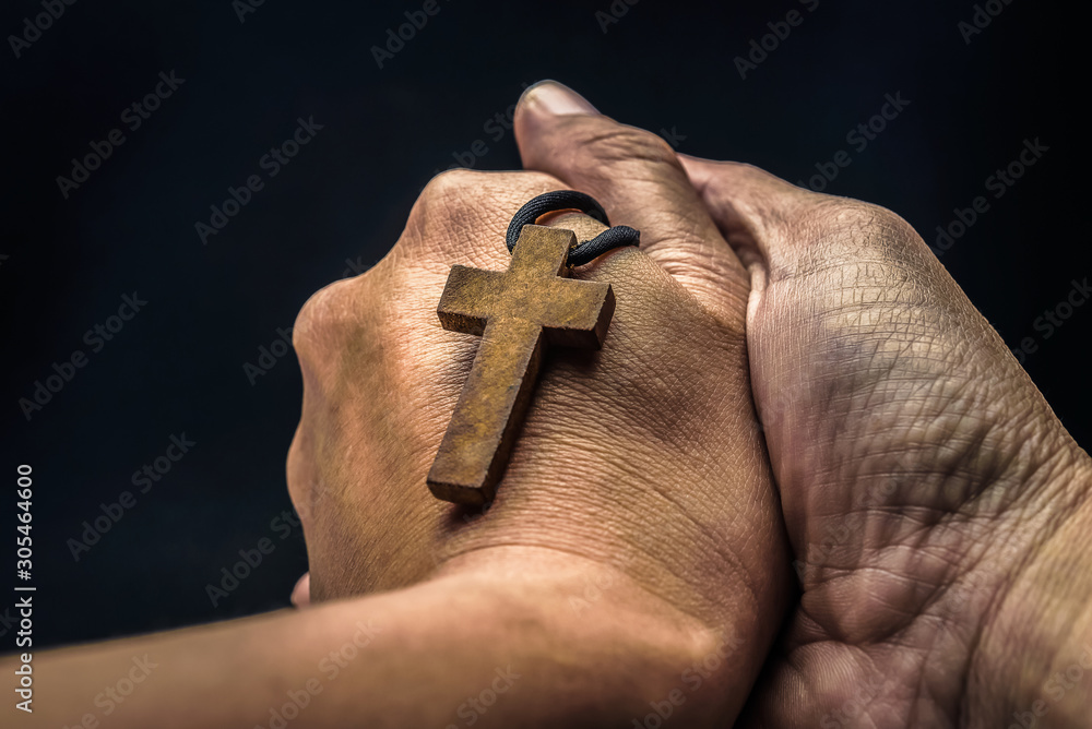 Φωτογραφία The crucifix is in the hands of a man who is praying for the blessing of his god with faith
