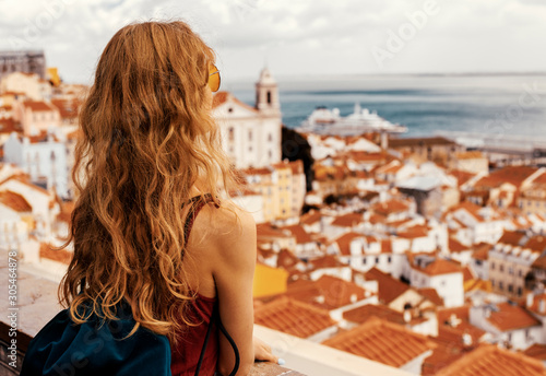 Traveller wearing a bag and white shirt exploring beautiful cityscape of Iberic country in Europe during summer sunset