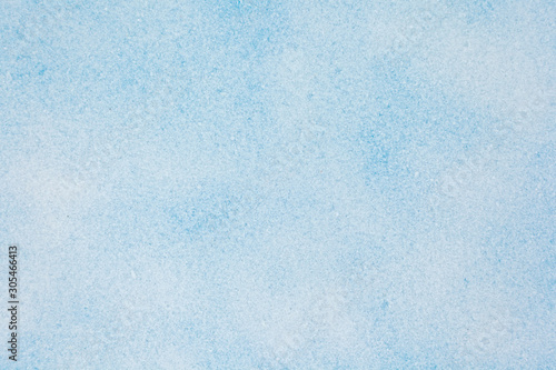 Winter background. Top view of snow texture on the blue background. Copy space.
