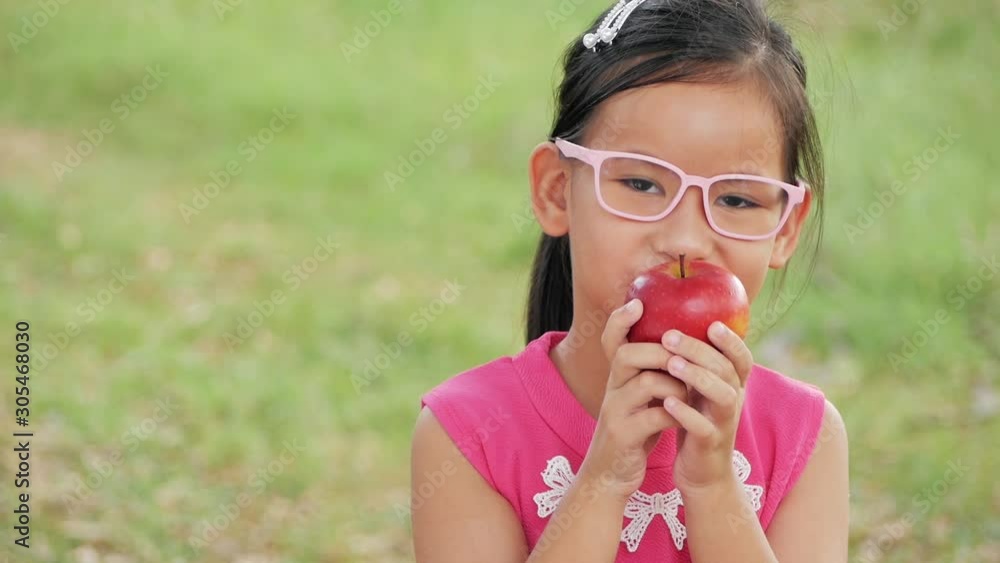 Preschool girl eating red apple. Girl chewing red apple. Preschool girl eating red apple. Girl chewing red apple.