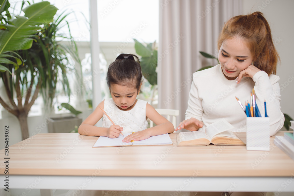 Mother helping her little child with homework Mother helping her little child with homework