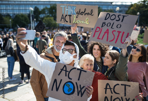 People with placards and protective suit on global strike for climate, taking selfie. © Halfpoint