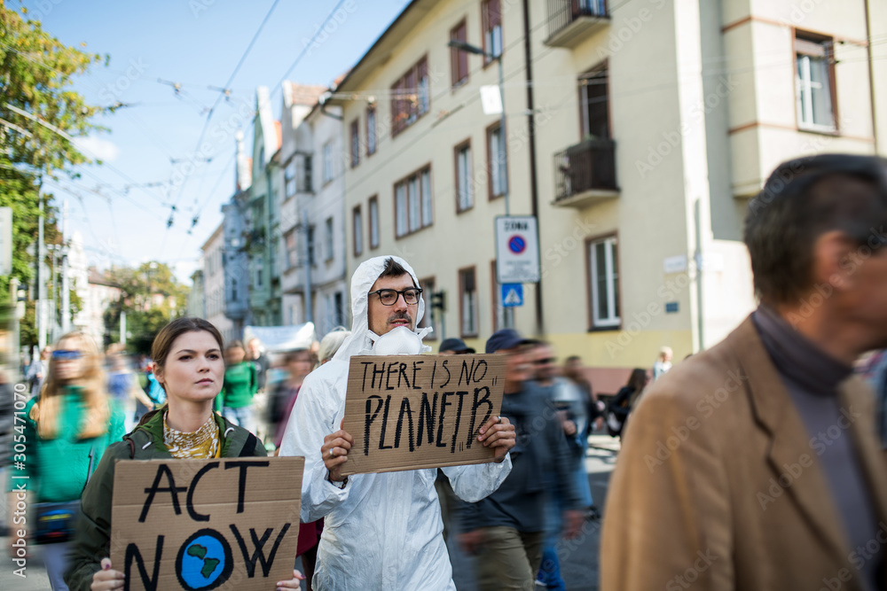 Fototapeta premium People with placards and protective suit on global strike for climate change.