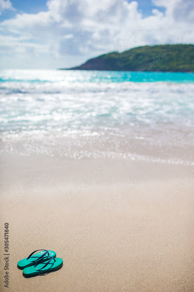 Summer mint flip flops with sunglasses on white beach