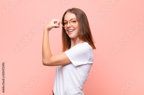 Photographie young red head woman feeling happy, satisfied and powerful, flexing fit and musc