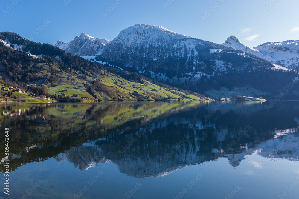 snowcapped mountains in blue sky  reflected in lake Waeggitalersee