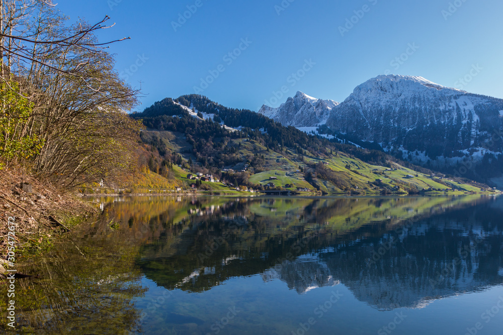 Fototapeta premium snowcapped mountains reflected in lake Waeggitalersee and blue sky